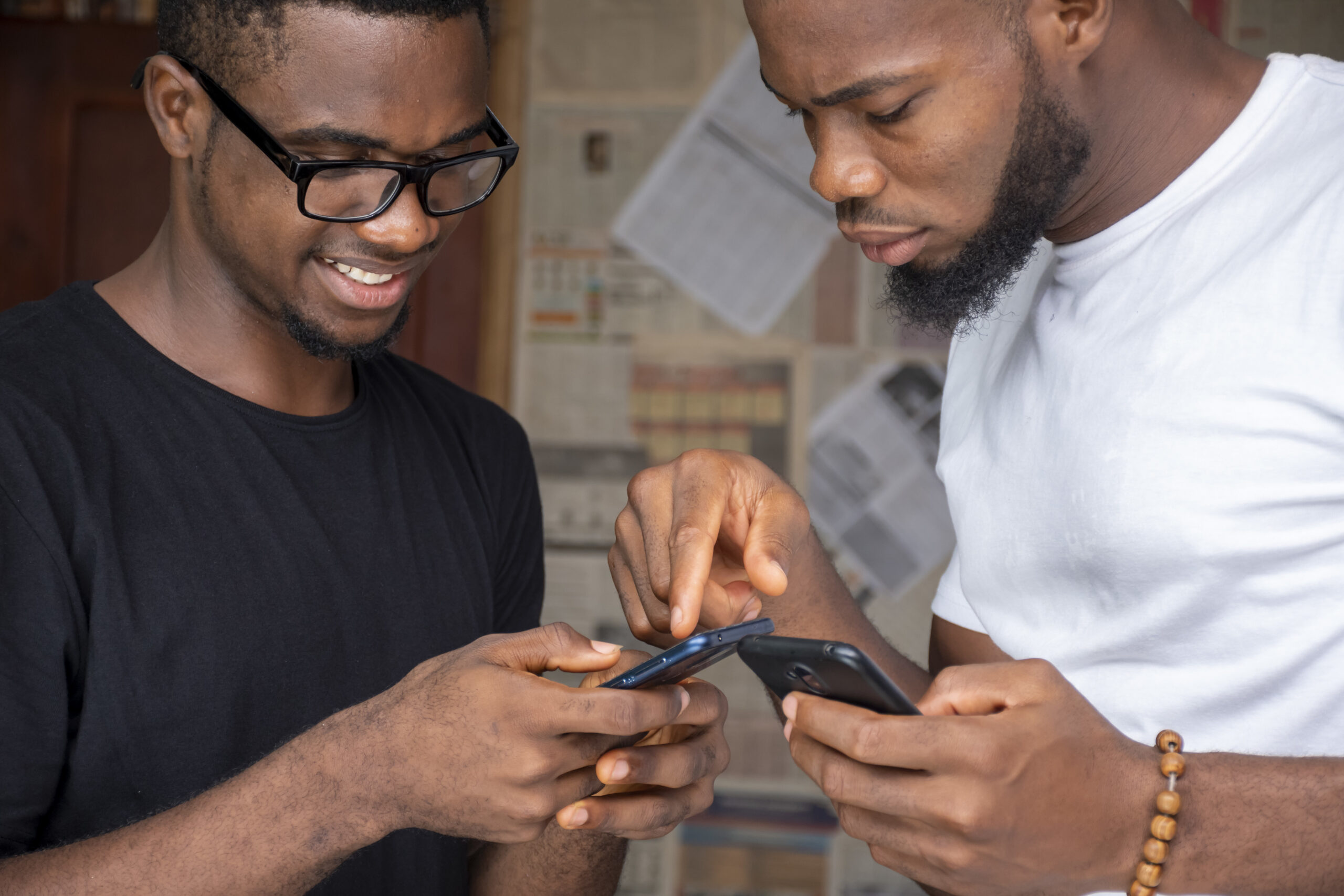 shallow focus of two young african males sharing content through their phones